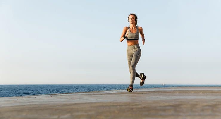 This image shows a person with a prosthetic running on a coastal path