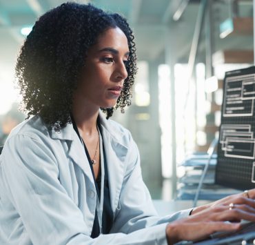 Healthcare professional reviewing AI-generated clinical insights alongside patient data in a modern hospital environment.