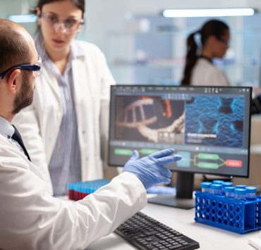 Researchers working in a biotechnology laboratory as pharmaceutical companies increase acquisitions to strengthen future drug pipelines.