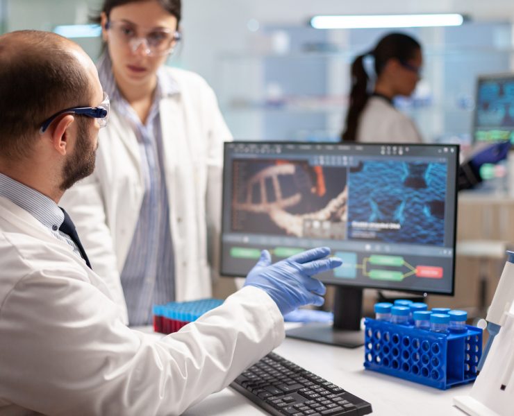 Researchers working in a biotechnology laboratory as pharmaceutical companies increase acquisitions to strengthen future drug pipelines.