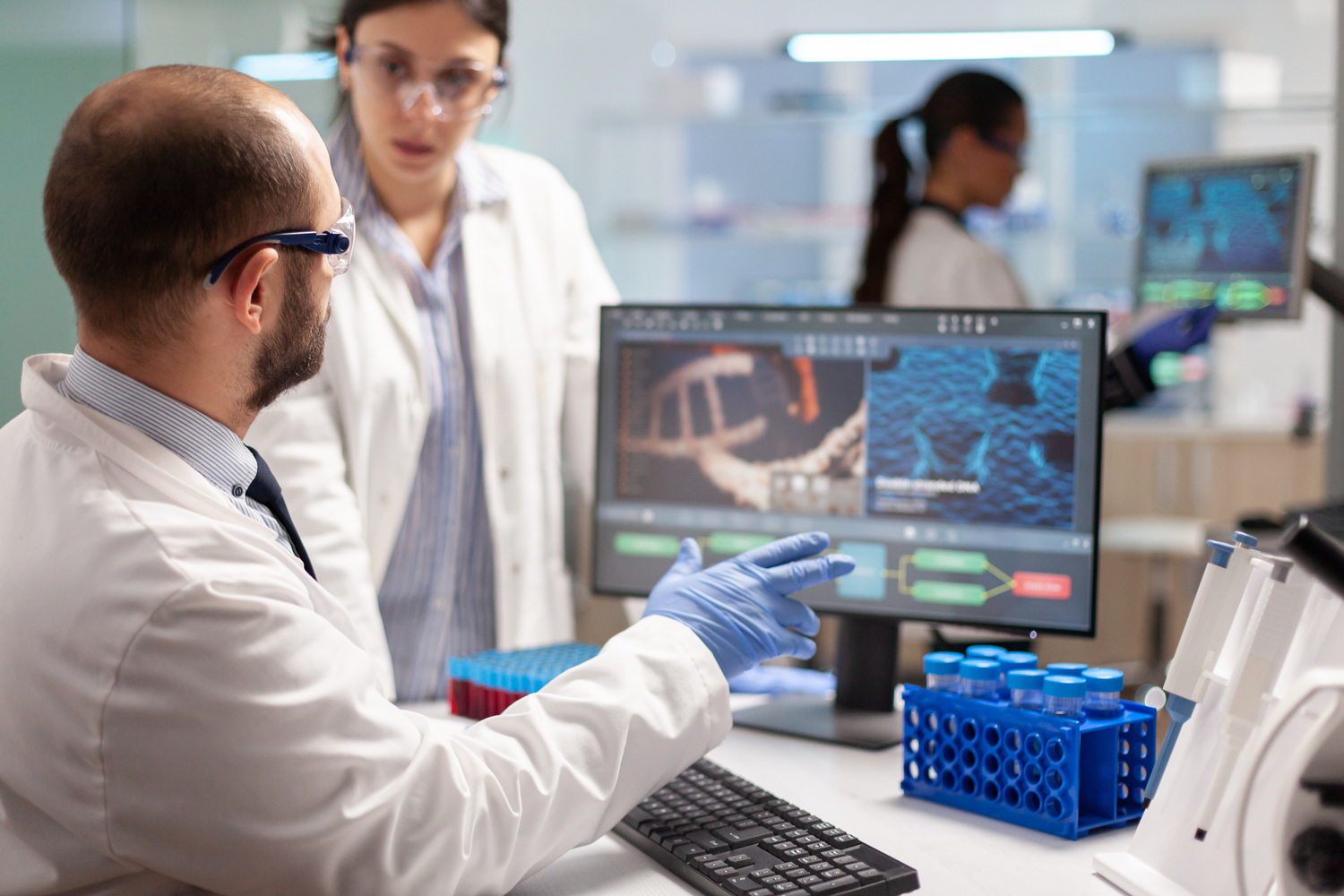 Researchers working in a biotechnology laboratory as pharmaceutical companies increase acquisitions to strengthen future drug pipelines.