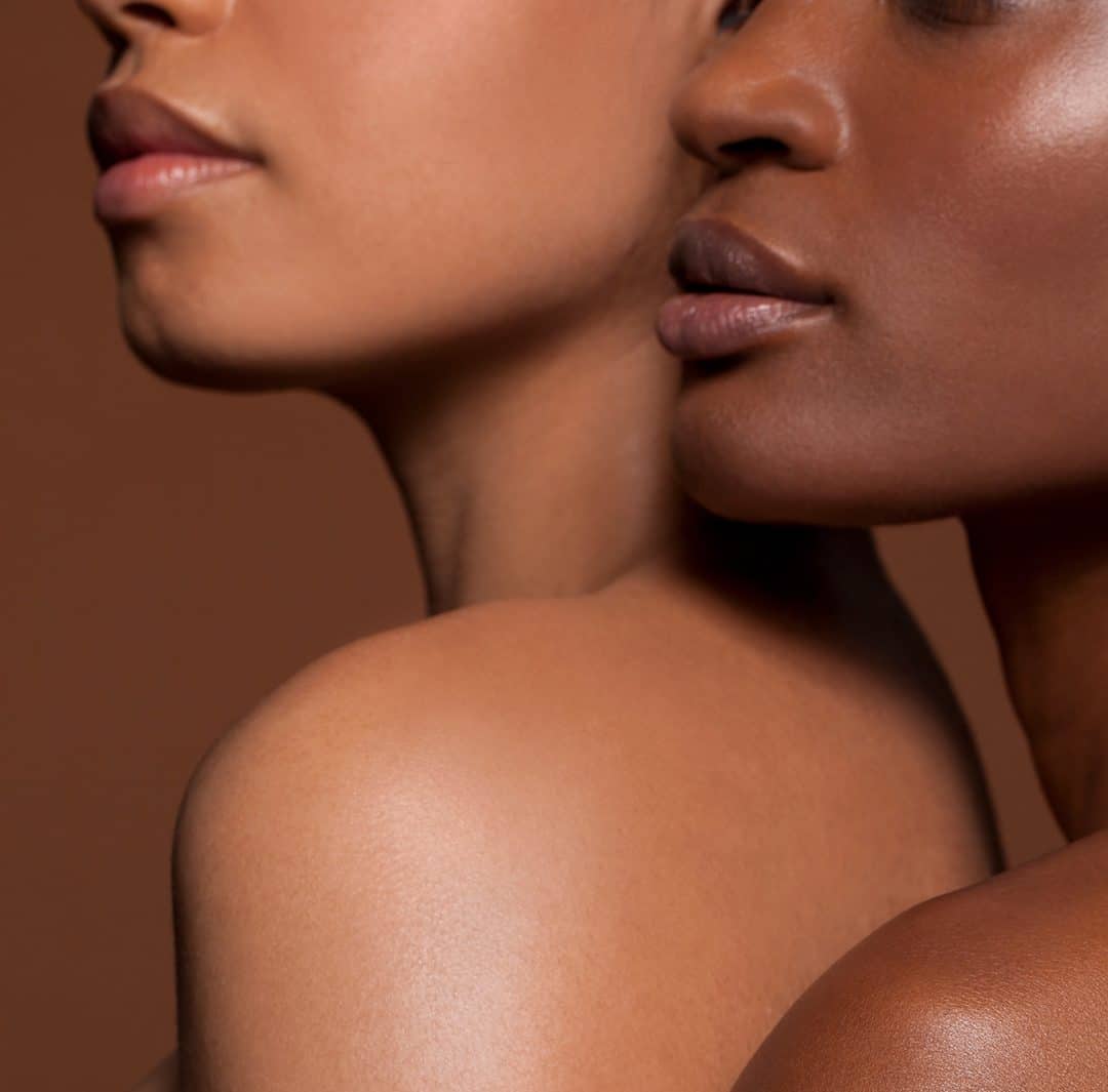 a close-up portrait of two individuals highlighting diverse skin tones and textures