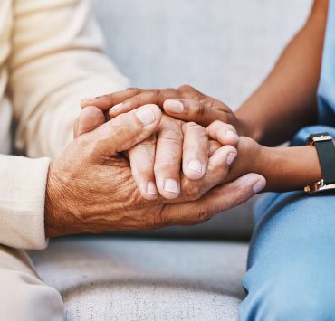 a close-up, supportive interaction between two individuals sitting next to each other