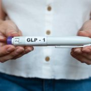 A woman holding a GLP-1 weight loss drug as manufacturers developing next-generation obesity and weight loss medicines.