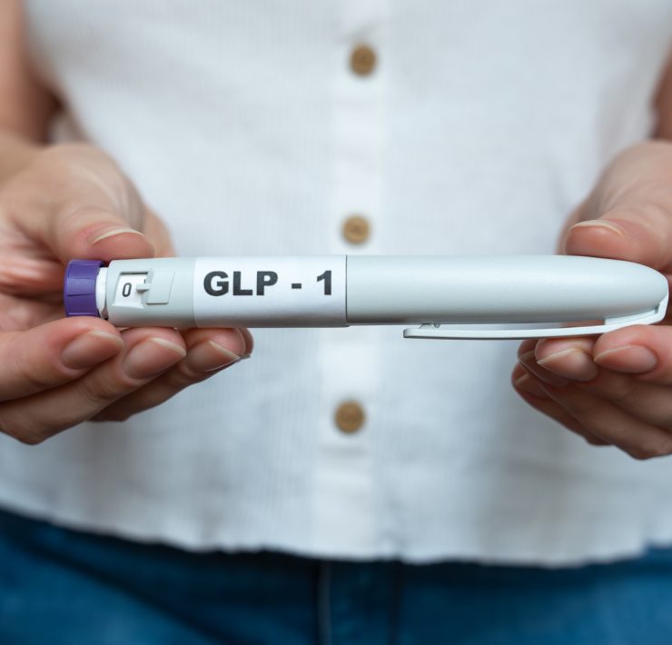 A woman holding a GLP-1 weight loss drug as manufacturers developing next-generation obesity and weight loss medicines.