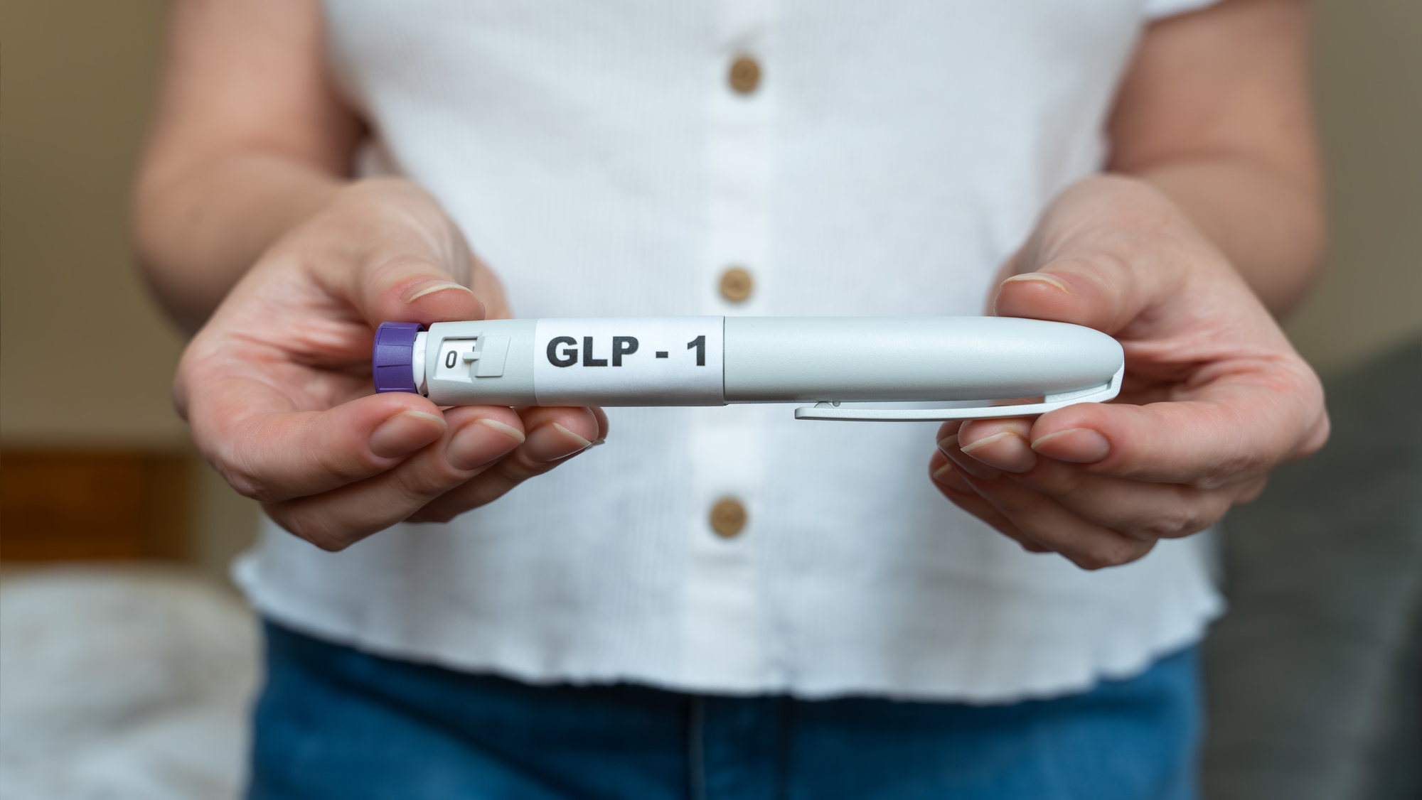 A woman holding a GLP-1 weight loss drug as manufacturers developing next-generation obesity and weight loss medicines.