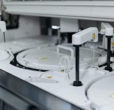 **Alt text:** Automated laboratory equipment performing high-throughput sample processing and analysis.