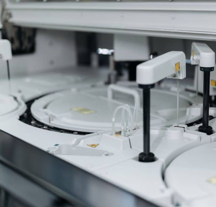 **Alt text:** Automated laboratory equipment performing high-throughput sample processing and analysis.