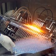 Automated pharmaceutical manufacturing equipment processing vials on a high-speed production line.