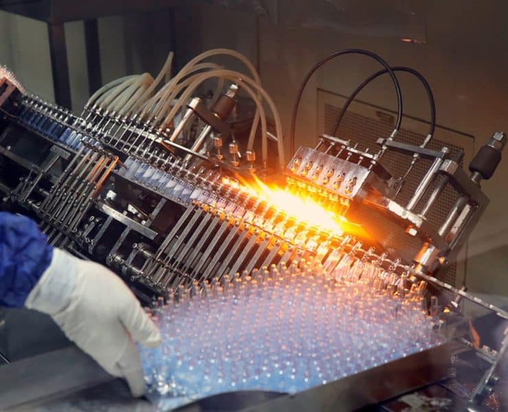 Automated pharmaceutical manufacturing equipment processing vials on a high-speed production line.