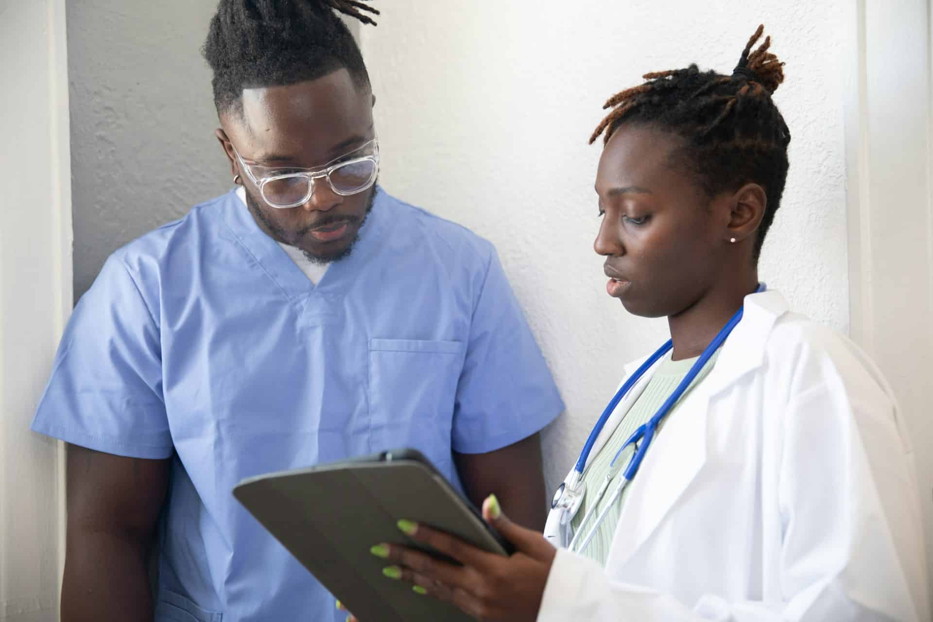 Healthcare professionals reviewing information on a tablet during clinical training.