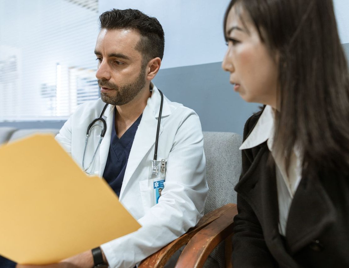 Doctor reviewing medical records with a patient during a spine surgery consultation.