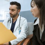 Doctor reviewing medical records with a patient during a spine surgery consultation.