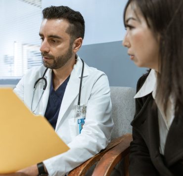 Doctor reviewing medical records with a patient during a spine surgery consultation.