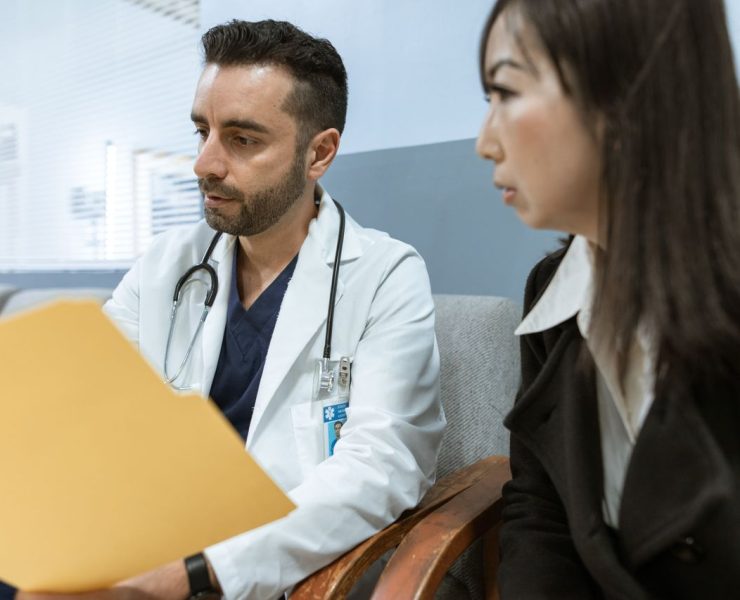 Doctor reviewing medical records with a patient during a spine surgery consultation.