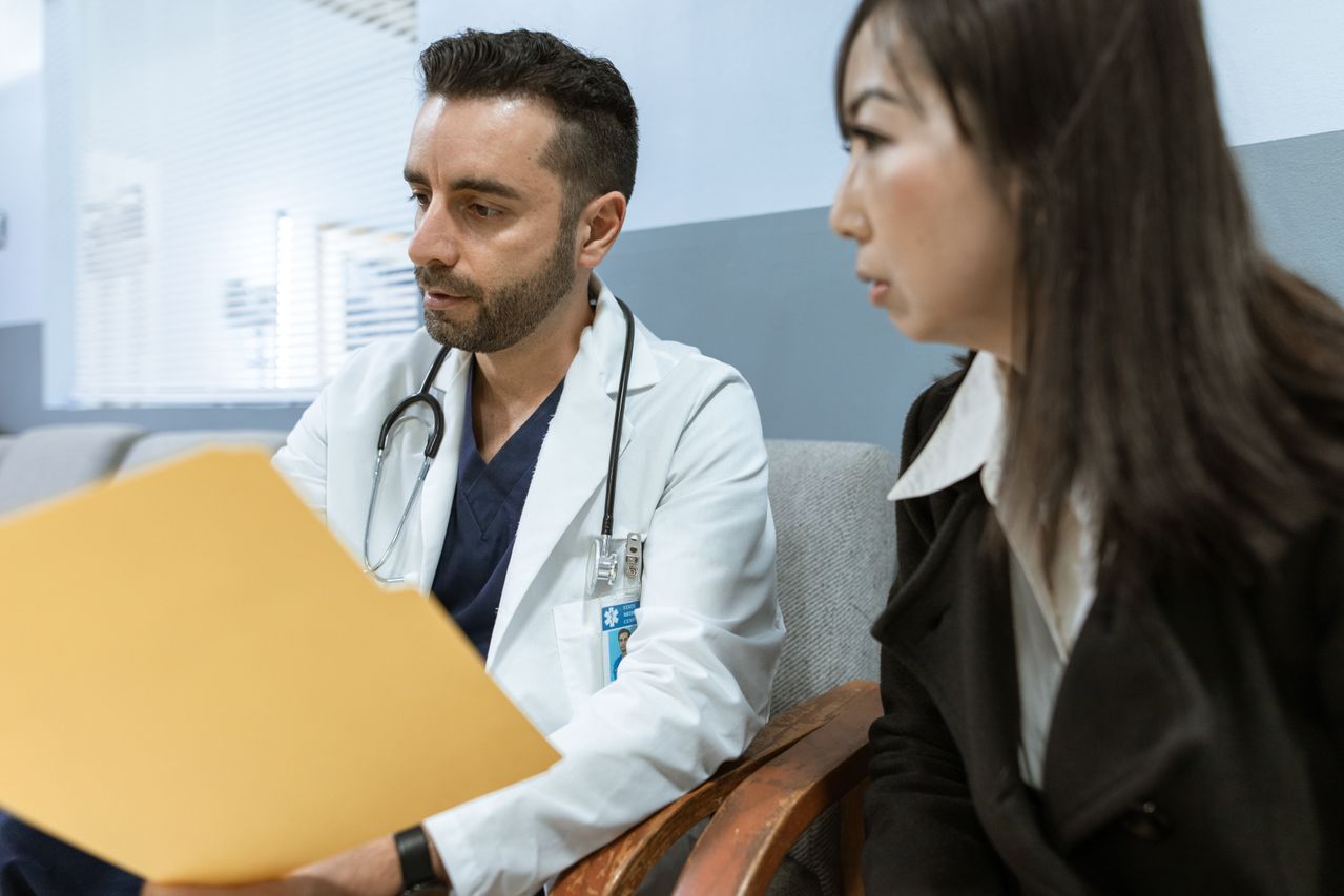 Doctor reviewing medical records with a patient during a spine surgery consultation.