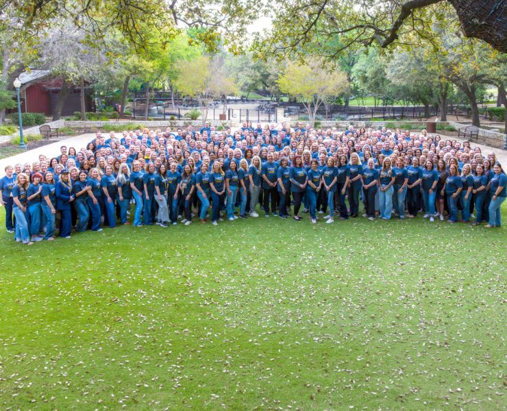 a large group photo of employees and leaders from Compassus gathered on the lawn during a company event