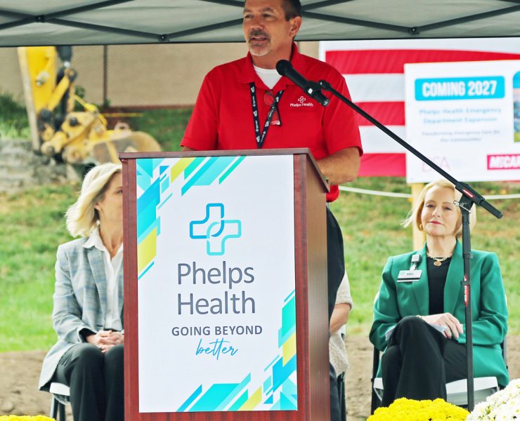 a podium and banner for Phelps Health with the slogan "GOING BEYOND better"