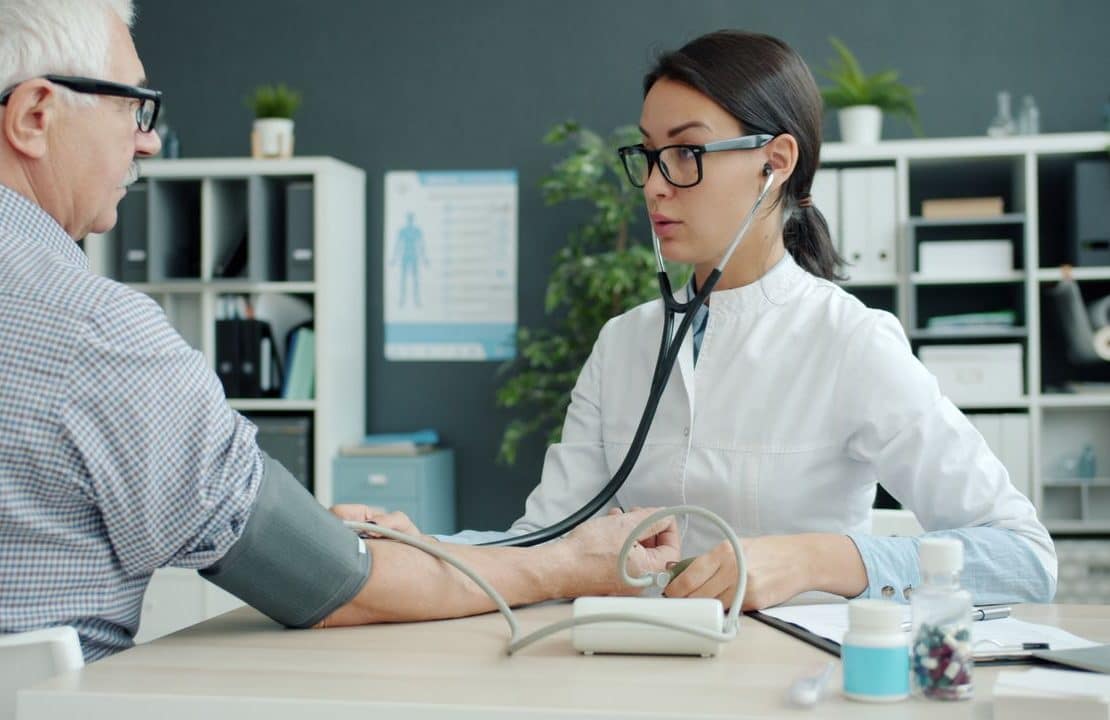 Physical therapist guiding a patient through knee rehabilitation exercises in an outpatient clinic