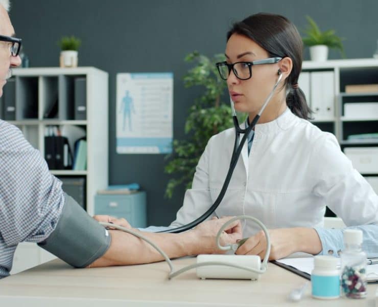 Physical therapist guiding a patient through knee rehabilitation exercises in an outpatient clinic